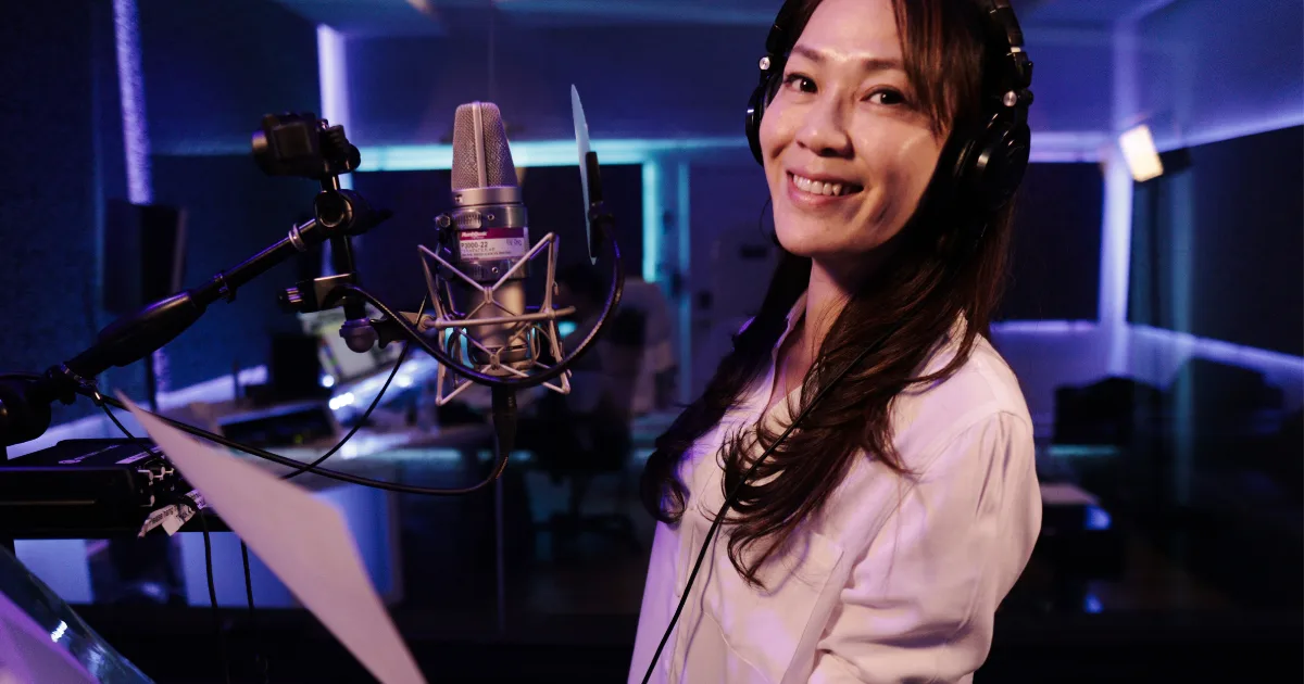 Voice actor on headphones at a condenser microphone with a script page on the stand at MIX Recording Studio, Los Angeles