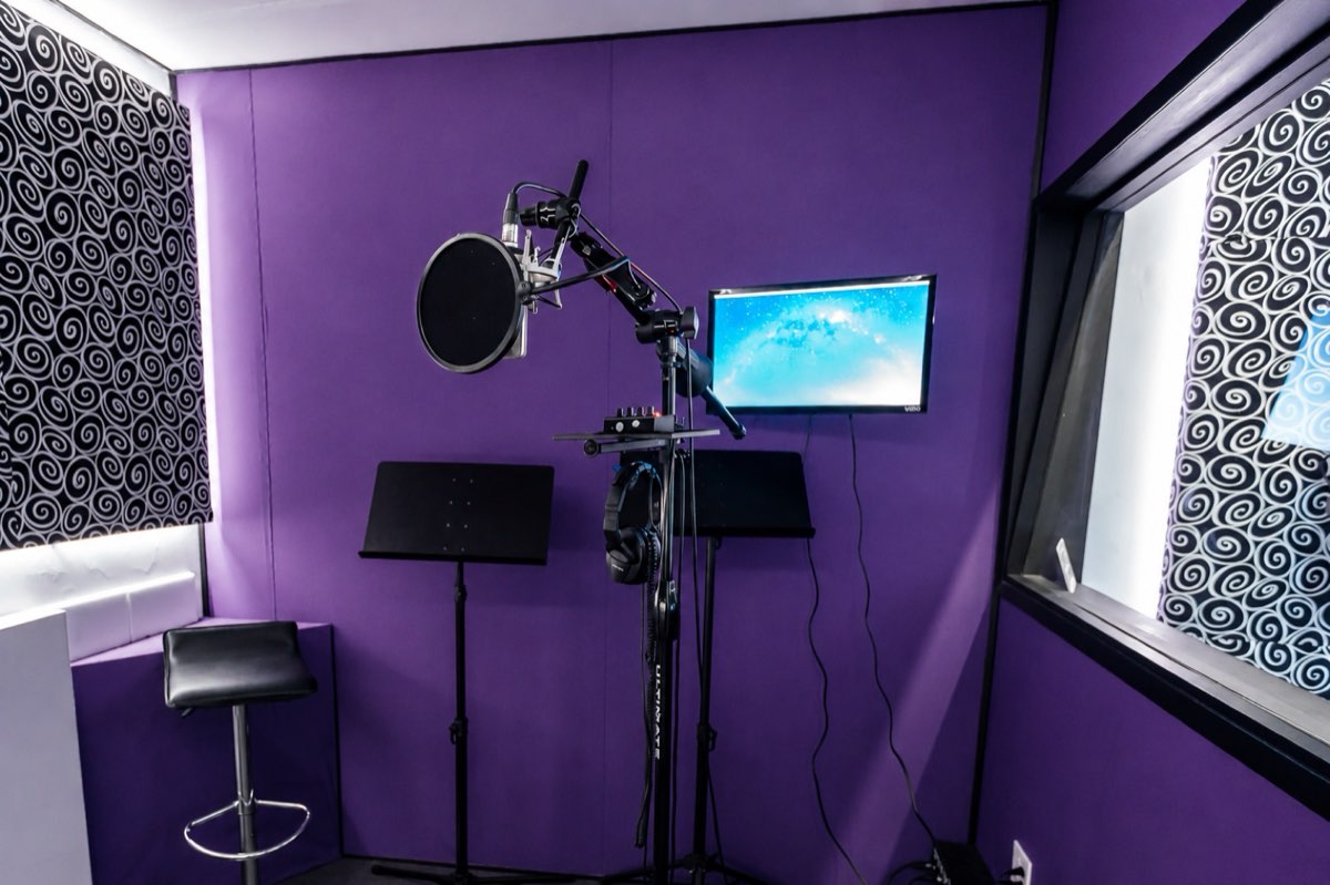 Vocal booth at MIX Recording Studio in Los Angeles with a condenser microphone, pop filter, headphones, and purple acoustic wall panels