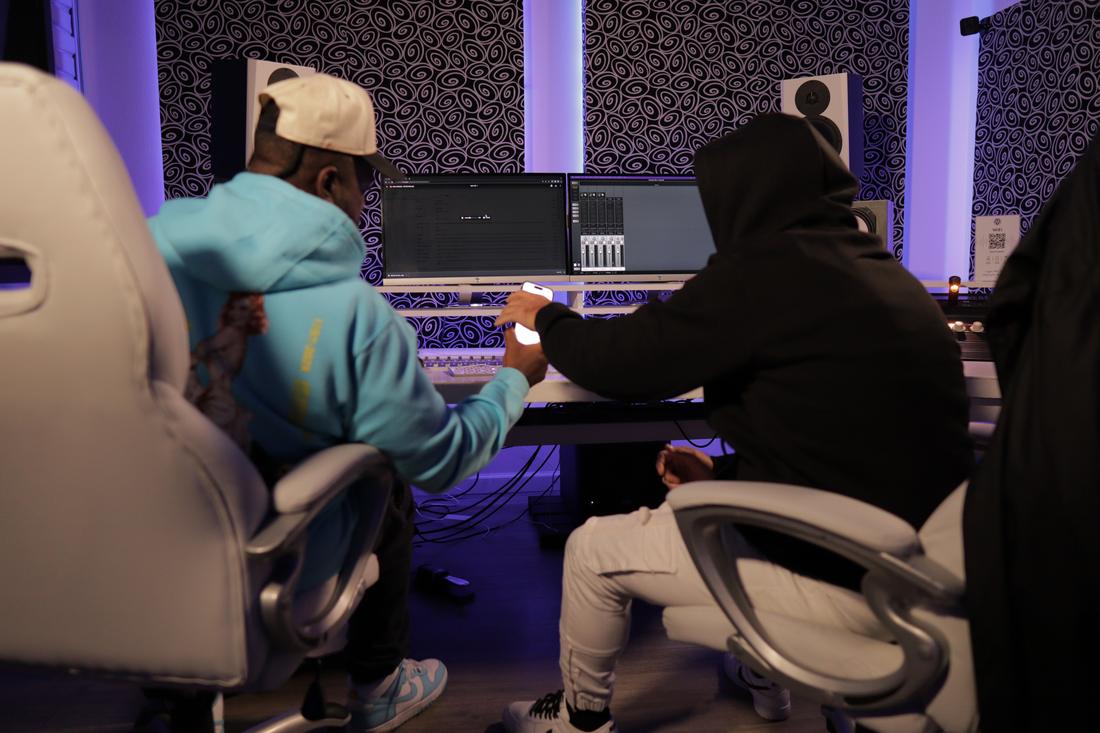 A producer and a writer working side by side at the console during a session